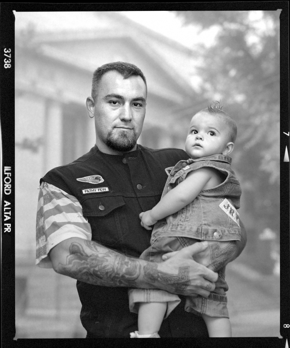 Editorial photography of motorcycle club member with son stands outside of Prescott Arizona Courthouse by Phoenix commercial photographer Jason Koster.