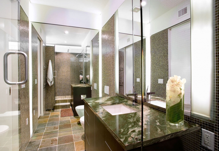 Editorial photography of modern style bathroom with mirror wall, glass shower and green granite countertops by Phoenix commercial photographer Jason Koster.