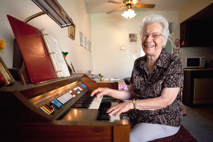 Editorial photography of grandma laughs while playing multi manual organ by Phoenix commercial photographer Jason Koster.